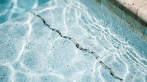 Close-up of a hairline crack in pool plaster underwater in a Miami residential pool