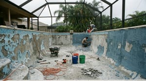 Drained pool mid-renovation showing concrete shell and construction tools in Miami-Dade