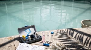 Cloudy pool water and a chemistry test kit at a Miami home in peak summer