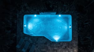 Overhead night view of a Miami backyard pool glowing blue from underwater LED pool lights